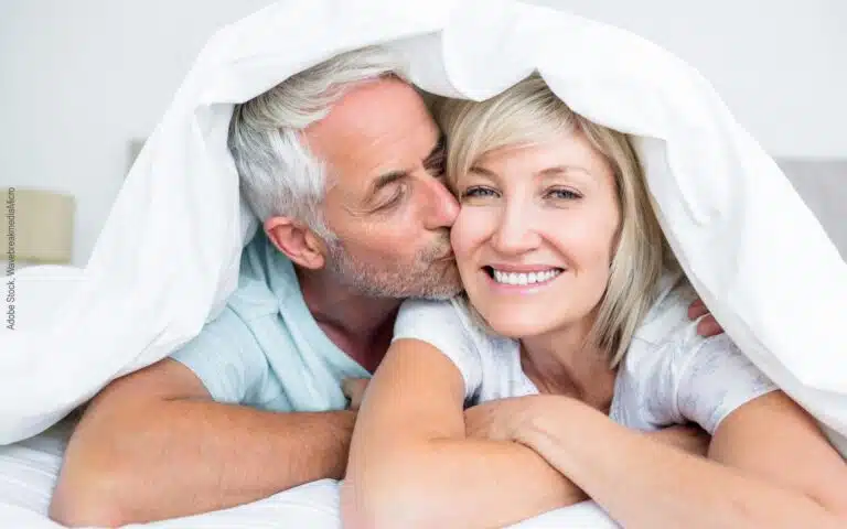 un couple d'âge moyen sous une couette