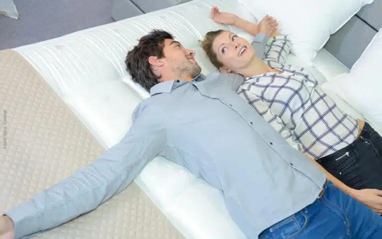 jeune couple allongé qui essaye un matelas