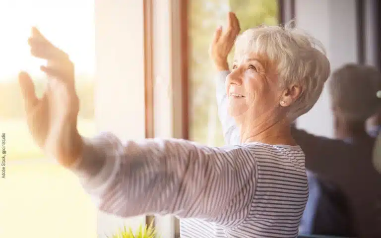 une femme ouvre ses fenêtres pour aérer