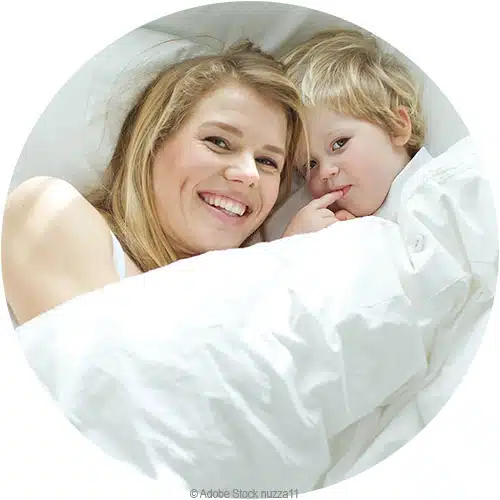 une maman et son jeune garçon sous une couette