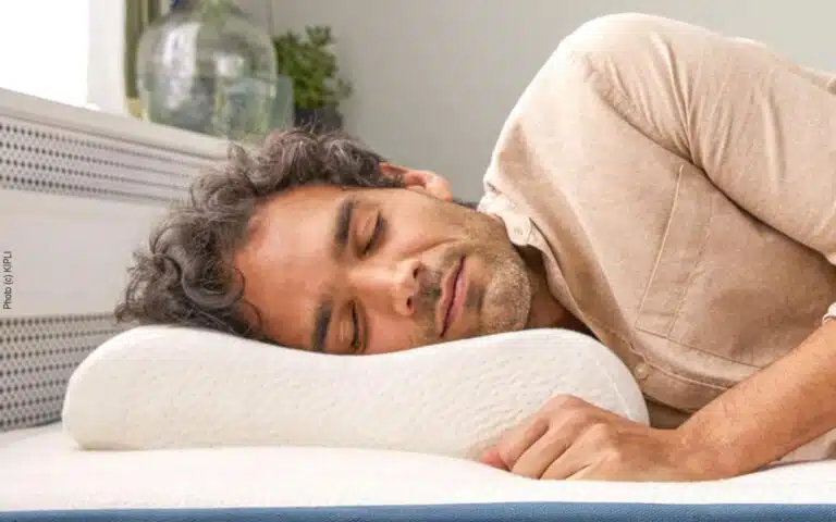 un homme dort avec un oreiller ergonomique