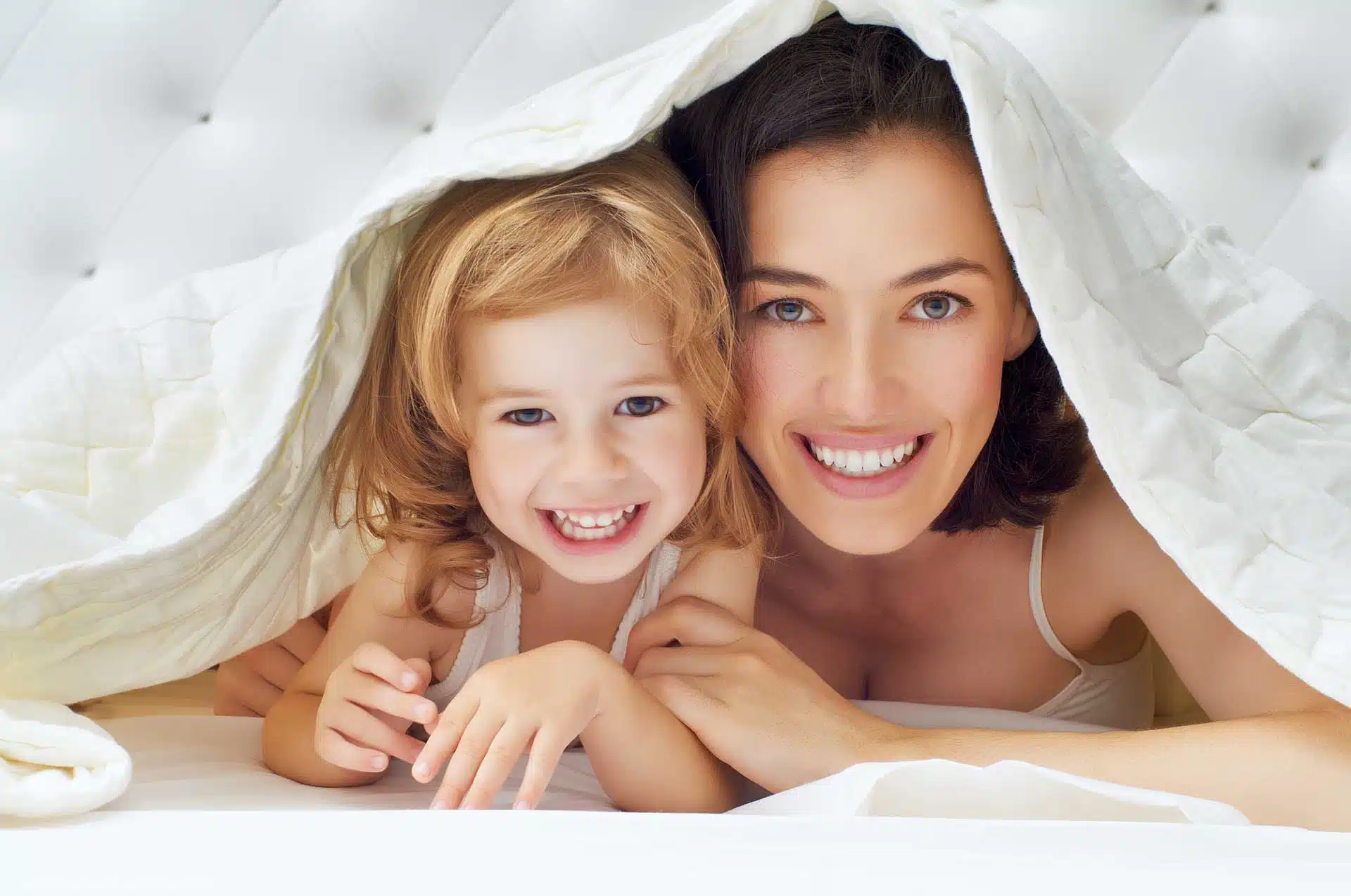 une maman et sa petite fille sous une couette