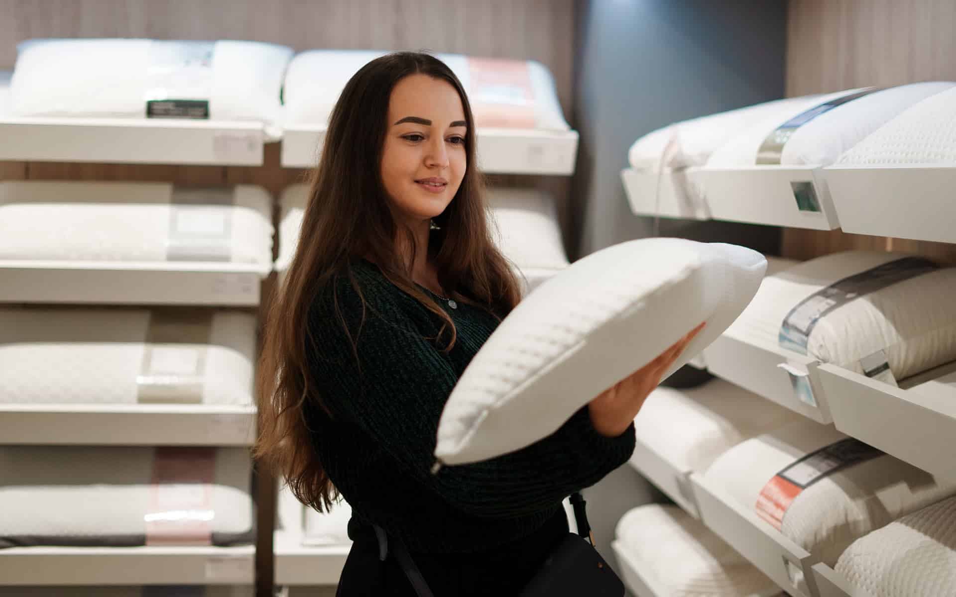 une femmecompare les oreillers dans un magasin