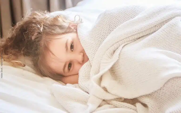 une petite fille enroulée dans une jolie couverture douce