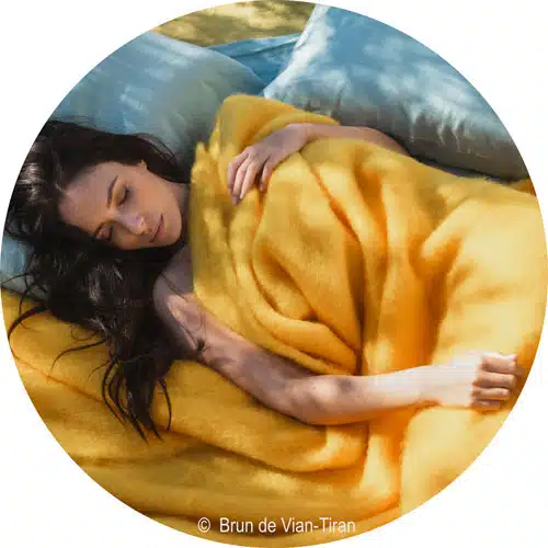 une jeune femme blottie dans une couverture jaune tournesol