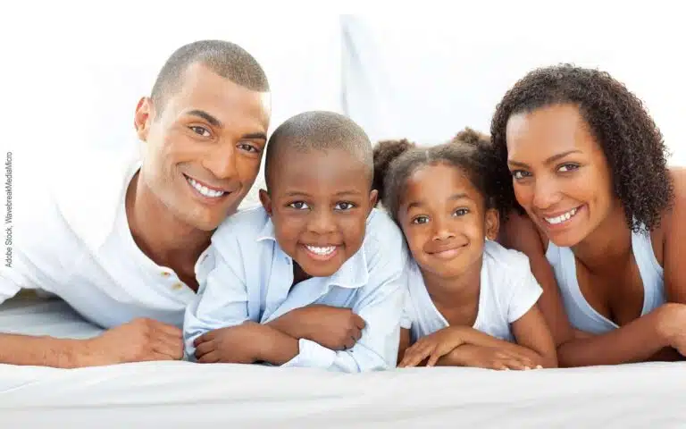 une famille de 4 personnes allongés sur un lit