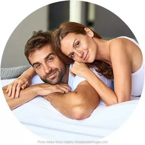 le sourire d'un couple allongé sur son lit