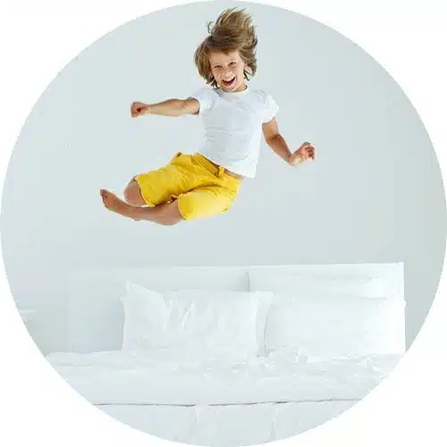 jeune garçon qui saute sur un lit