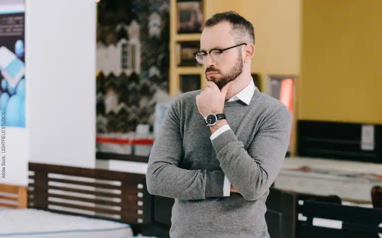 homme qui réfléchit dans un magasin de literie
