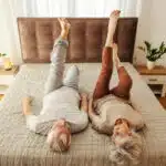 un couple senior allongé sur son lit étire ses jambes