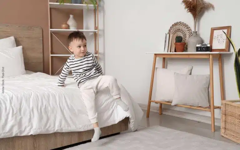 un petit enfant descend d'un lit