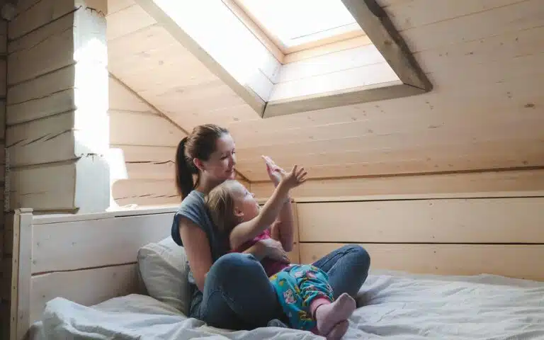 une jeune maman et sa petite fille dans une petite chambre