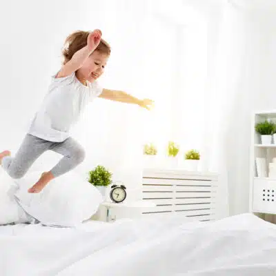 un gamin saute à pieds joints sur un matelas