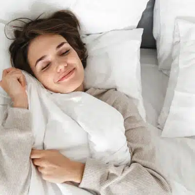 une femme souriante dans sa couette