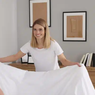 une juene femme prépare son lit