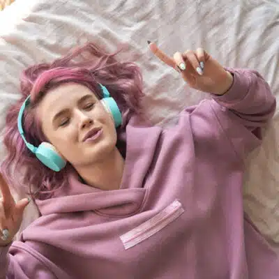 une jeune ado avec son casque de musique sur son lit