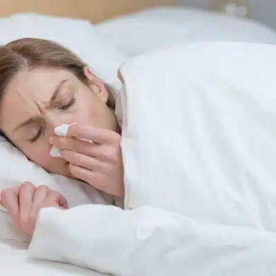 une femme souffre d'allergie dans son lit