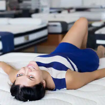 une femme regarde à l'envers allongée sur un matelas
