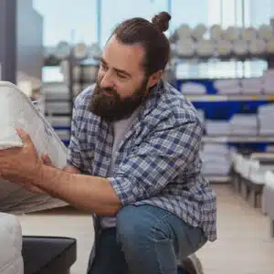 un homme barbu évalue un matelas en mousse