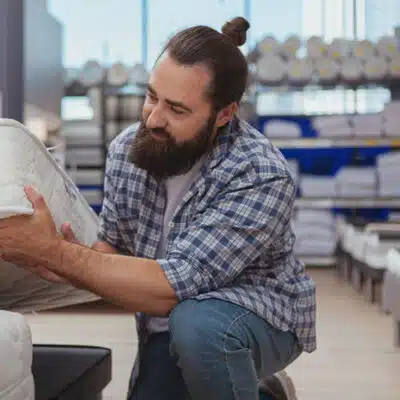 un homme barbu évalue un matelas en mousse