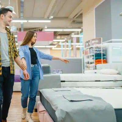 un couple hésite devant plusieurs matelas