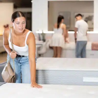 une jeune femme en t-shirt avec la main sur un matelas