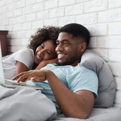 jeune couple qui surfe depuis son lit