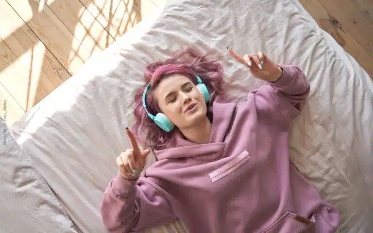 une ado écoute de la musique sur son lit