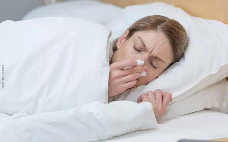 une femme se mouche dans son lit