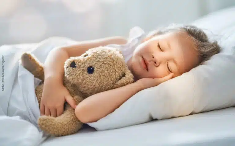 un nounours avec une petite fille qui dort