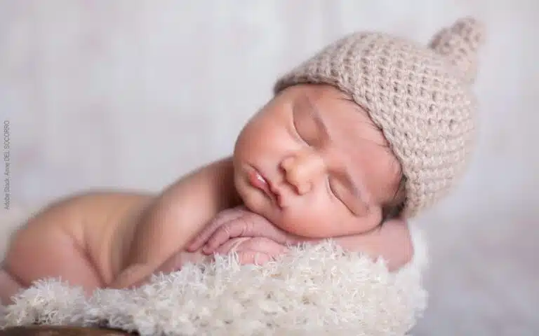 un bébé dort avec un bonnet en laine