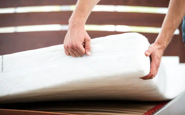 un homme vérifie l'épaisseur d'un matelas