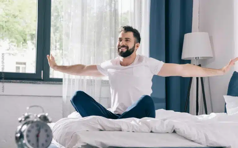un homme barbu s'étire sur son matelas latex