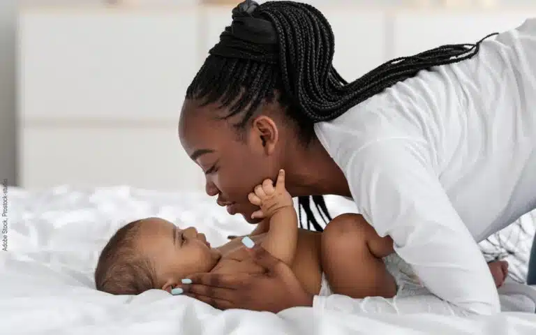 une jeune maman embrasse son bébé