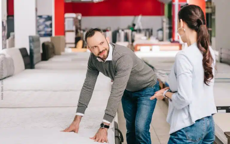un couple discute du choix d'un nouveau matelas dans un magasin