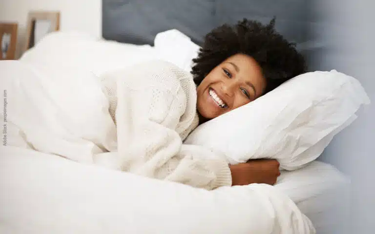une femme très souriante serre son oreiller