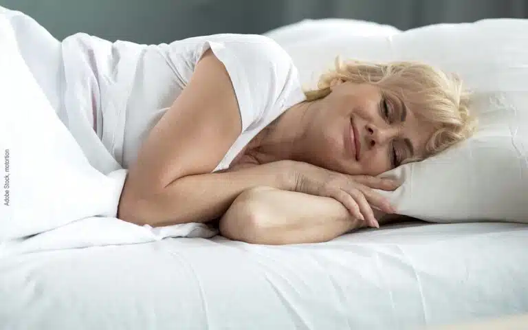 une femme dort dans un linge de lit en percale de coton