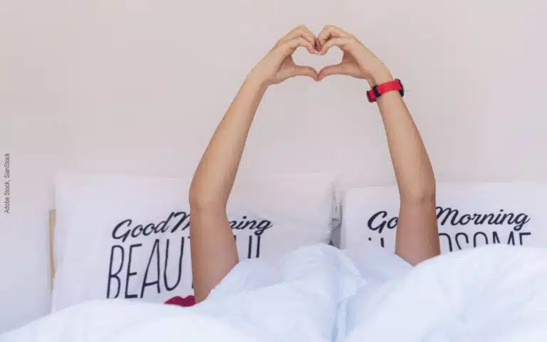 un dormeur fait un coeur avec ses mains