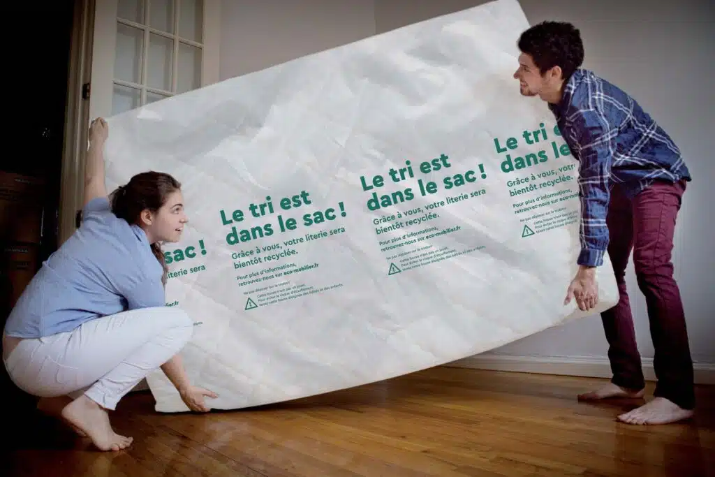 un jeune couple utilise un sac à matelas pour se débarasser de son vieux matelas