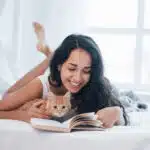 une jeune femme sur son lit avec son chat